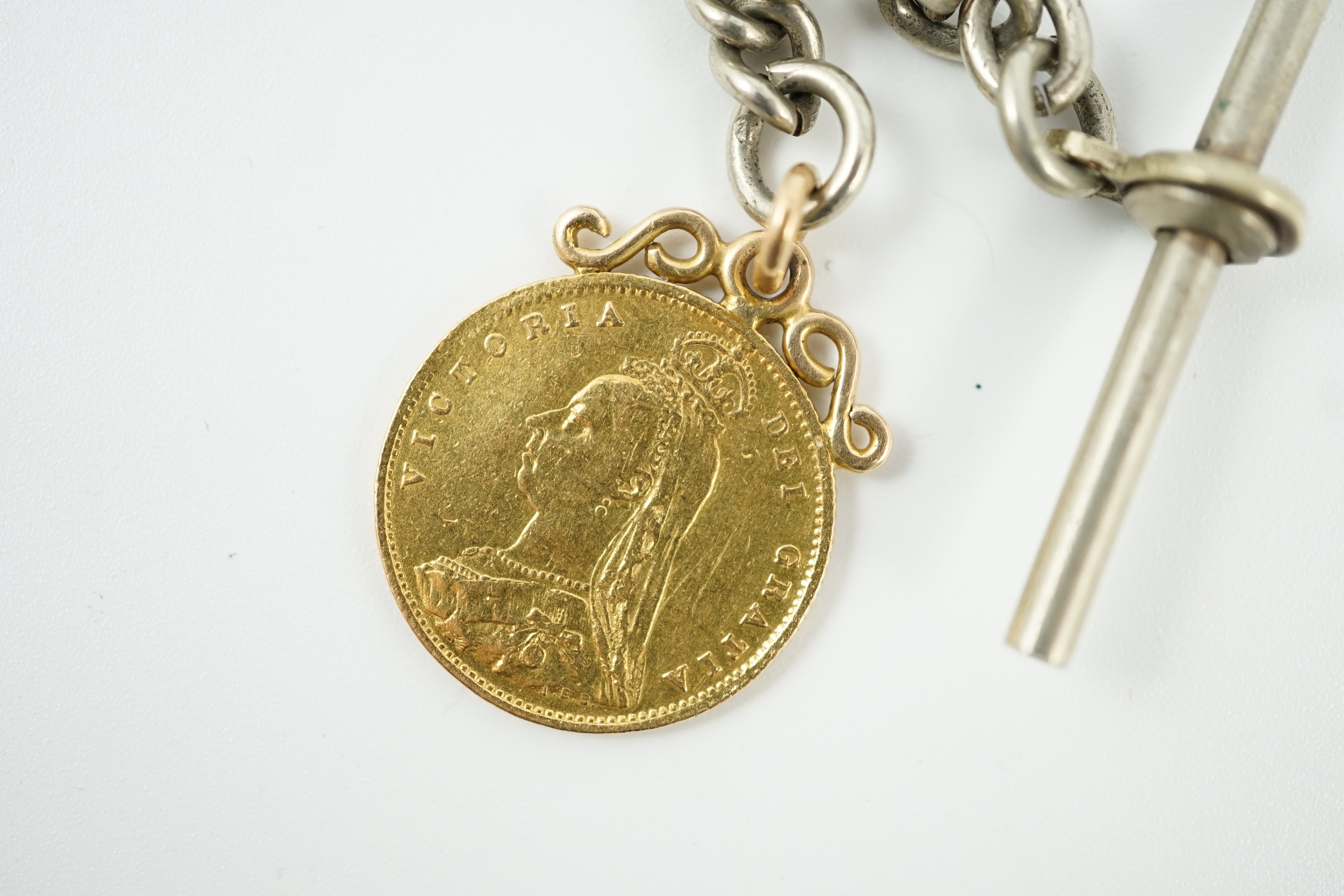 A Victorian 1887 gold half sovereign, on pendant mount and hung from a white metal albert.